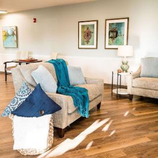 A cozy living room space featuring comfortable seating, decorative pillows, and modern artwork.