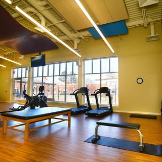 A well-lit gym with treadmills and exercise equipment.