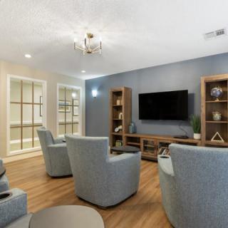 A modern living room with comfortable seating and a wall-mounted television.