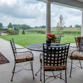 A peaceful patio setup with a table and chairs overlooking a lush garden.