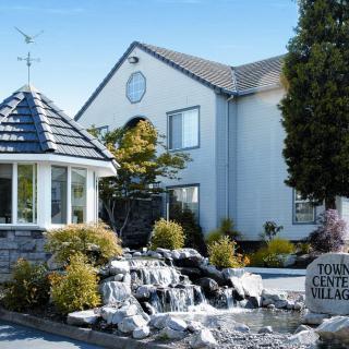 A well-maintained house with a landscaped garden, featuring a gazebo and stone pathway.