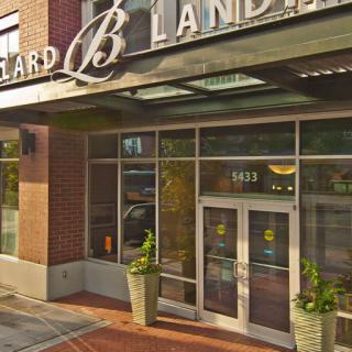 A modern storefront entrance with glass doors and large windows in an urban setting.