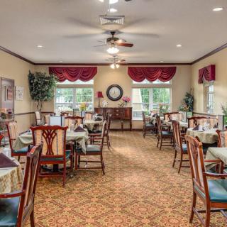 A well-decorated dining area with neatly arranged tables and chairs, featuring classic interior design elements.