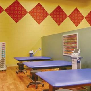 A physical therapy clinic with therapy tables and medical equipment.