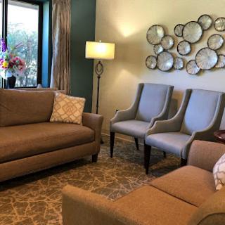 A cozy living room featuring a comfortable sofa, stylish armchairs, and decorative wall art.