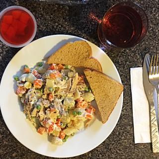 A hearty meal served with mixed vegetables, bread, and refreshing drinks.