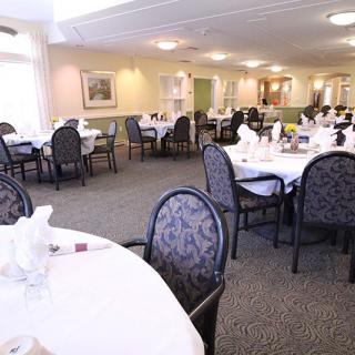 A spacious dining area with elegantly set tables and comfortable chairs.