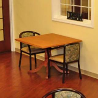 A wooden table with two chairs in an indoor dining area.