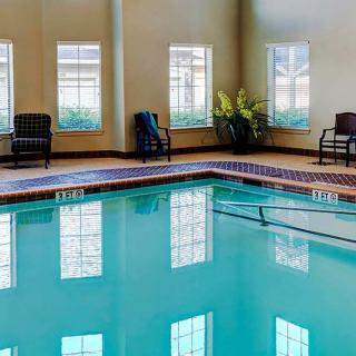 An inviting indoor swimming pool with seating and natural light.