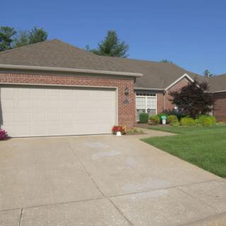 A suburban brick house with a driveway and attached garage.