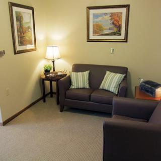 A cozy living room with a sofa, armchair, and decorative elements.