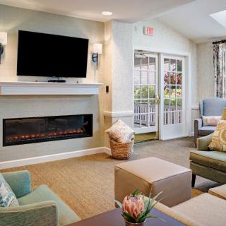 A cozy living room with modern decor, featuring a fireplace and television.