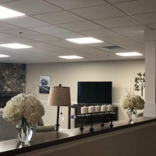 A modern living room with a television, sofa, and floral decorations.