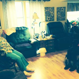 A cozy living room scene with people relaxing on the sofas.