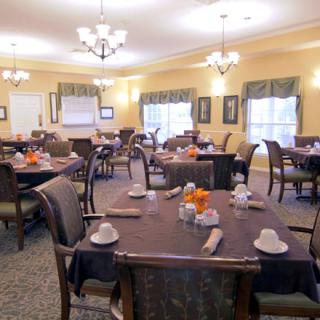 A well-arranged dining room with neatly set tables and elegant lighting.
