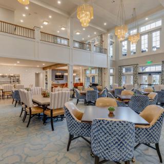 A spacious and well-lit lounge area with comfortable seating and large chandeliers.
