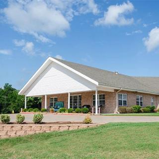 A suburban house with a well-maintained lawn and clear blue sky.