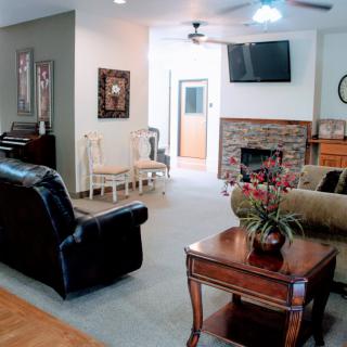 A cozy living room with a fireplace, sofas, and a mounted TV.