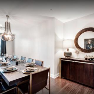 A modern dining room with elegant decor, featuring a stylish pendant light and a well-set dining table.