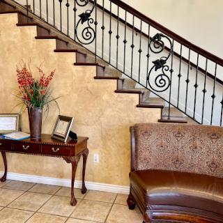 A beautifully designed interior featuring a staircase, elegant furniture, and decorative flowers.