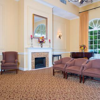 A well-furnished living room with elegant chairs, a fireplace, and a large window.