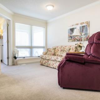 A cozy living room featuring a floral-patterned sofa and a burgundy armchair.