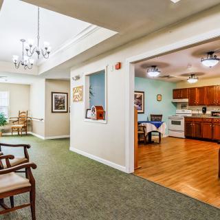 A cozy interior featuring a kitchen and dining area with wooden flooring and adjacent living space with carpet.