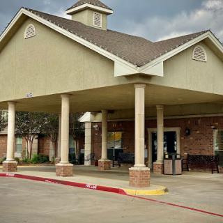 A welcoming hotel entrance with distinctive architectural features and a cloudy sky.