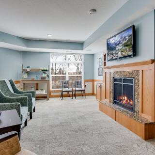 A cozy living room with a fireplace, television, and comfortable seating.