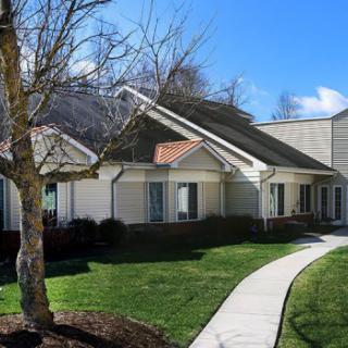 A suburban house with a well-maintained lawn and a sidewalk leading to the entrance.