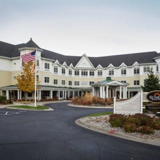A hotel building with a landscaped entrance and an American flag.