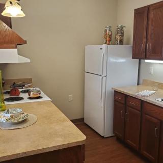 A cozy kitchen with wooden cabinets and modern appliances.