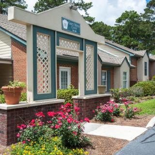 A well-maintained apartment entrance with attractive landscaping and blooming flowers.