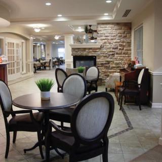 A cozy dining area with elegant furniture and a stone fireplace.