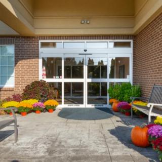 A building entrance decorated with colorful flowers and pumpkins for autumn.