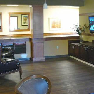 A cozy lobby area featuring comfortable seating and a wall-mounted television.