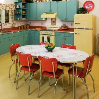 A retro kitchen with colorful cabinets and a vintage dining set.