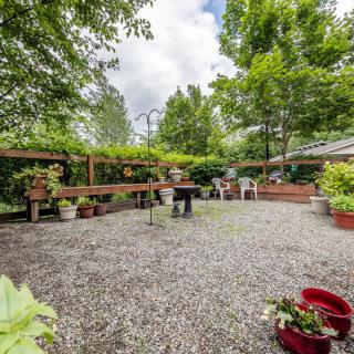A tranquil garden patio area with lush greenery and outdoor furniture.