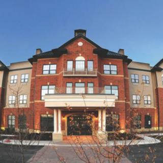 A multi-story residential building with a brick facade and central entrance.