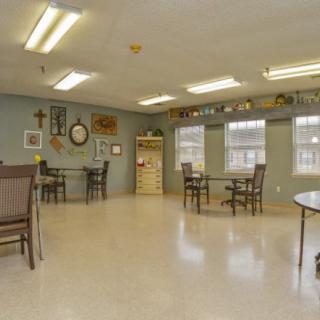 A spacious room with tables, chairs, and wall decor.