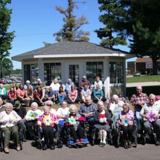 A cheerful gathering of seniors enjoying a sunny day together at their care facility.