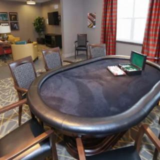 A poker table with chairs in a cozy game room setting.
