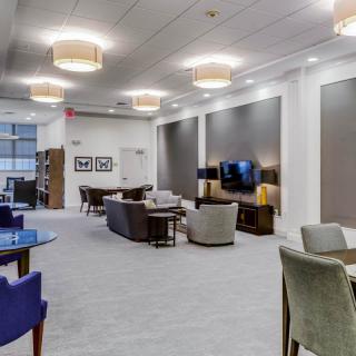 A modern lounge area with comfortable seating, stylish lighting, and a television set.