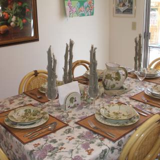 A beautifully set dining table with floral-themed dinnerware and decor.