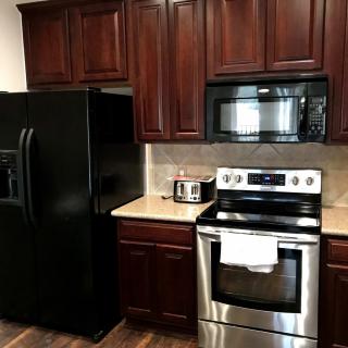 Modern kitchen with dark wooden cabinets and stainless steel appliances.