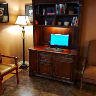 A cozy room with a computer desk and bookshelf setup.