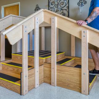 A person using an indoor rehabilitation staircase for physical therapy exercises.