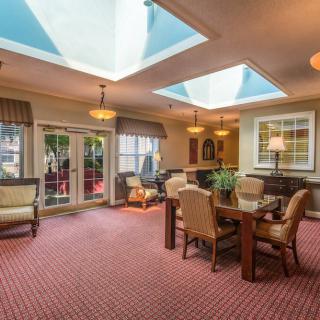 A cozy living room featuring large skylights, elegant furniture, and soft lighting.