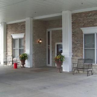 The building entrance features columns, seating, and decorative plants.