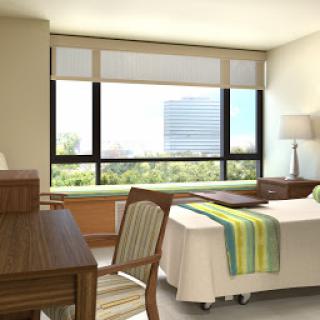 A well-lit hospital room featuring modern furnishings and a view of the outside.